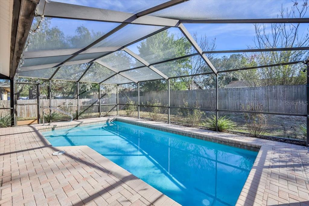 1382 Aladdin Road Spring Hill, FL 34609 - Photo 42 of 45 a view of a backyard with table and chairs under an umbrella