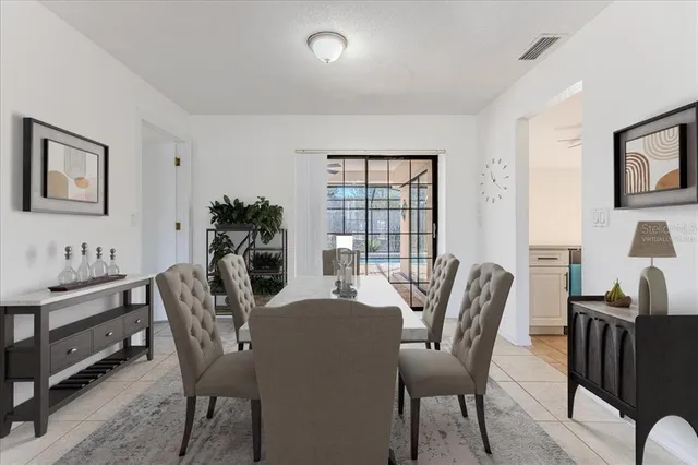 a dining room with furniture potted plants and wooden floor