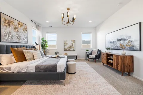 a spacious bedroom with a bed and a chandelier