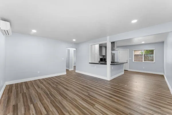 a view of empty room with wooden floor and windows