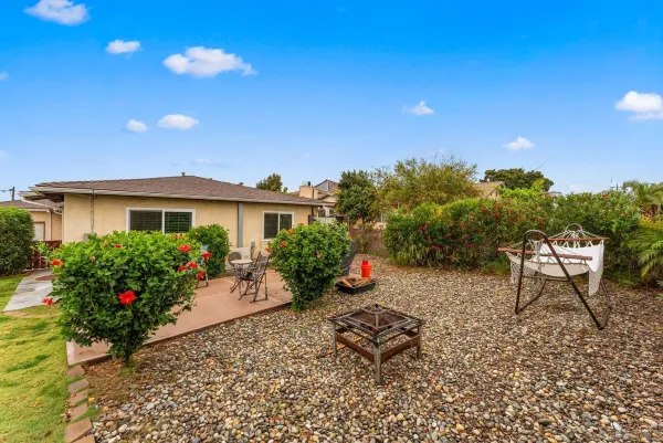 a view of a house with a backyard and sitting area