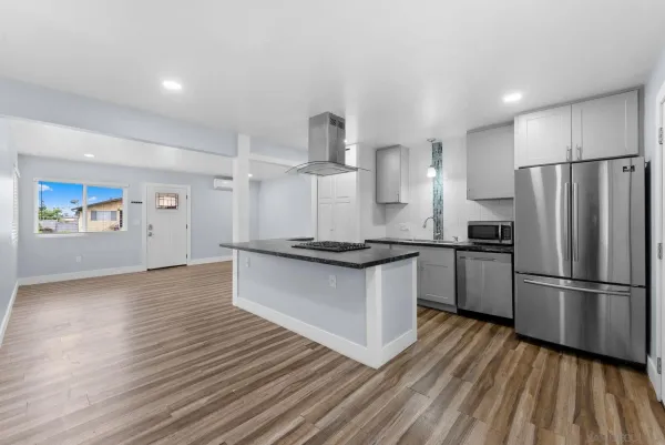 a kitchen with stainless steel appliances granite countertop a refrigerator and a stove top oven
