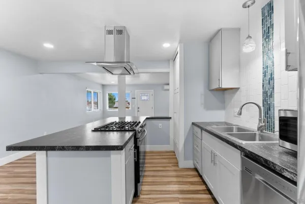 a kitchen with granite countertop a sink stainless steel appliances and cabinets