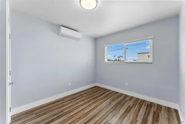 a view of a room with wooden floor and white walls