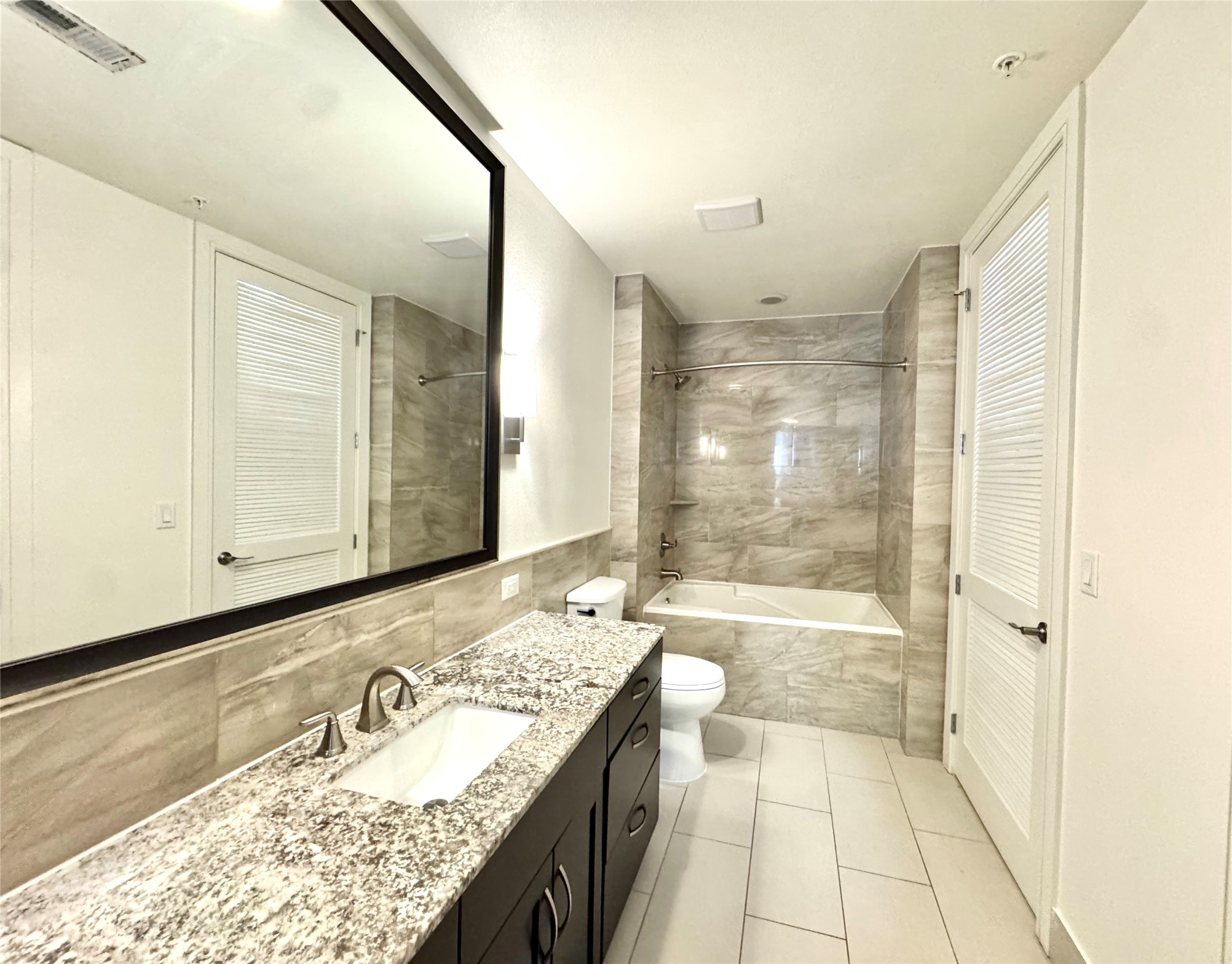 2303 Mid Lane, Unit 710 Houston, TX 77027 - Photo 14 of 19 a bathroom with a granite countertop sink mirror bathtub and shower