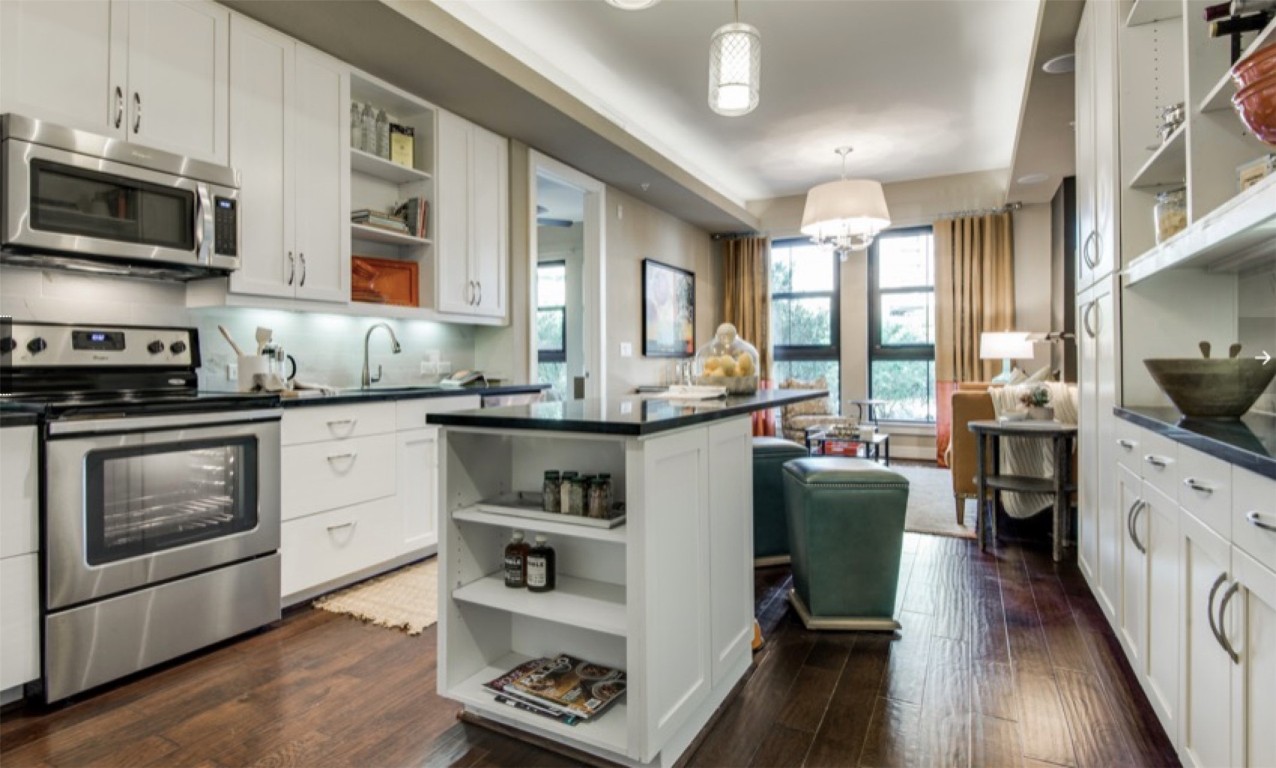 2303 Mid Lane, Unit 710 Houston, TX 77027 - Photo 3 of 19 a kitchen with stainless steel appliances kitchen island granite countertop a stove a sink and a microwave
