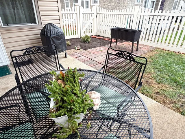 a patio with glass top table and chairs
