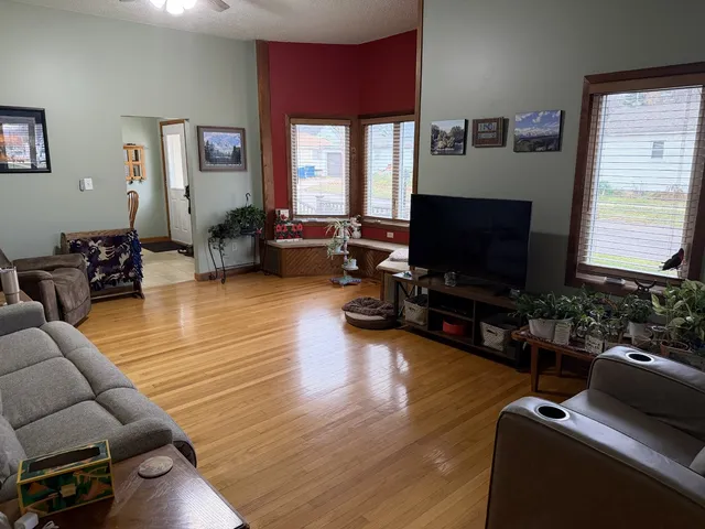 a living room with furniture flat screen tv and wooden floor