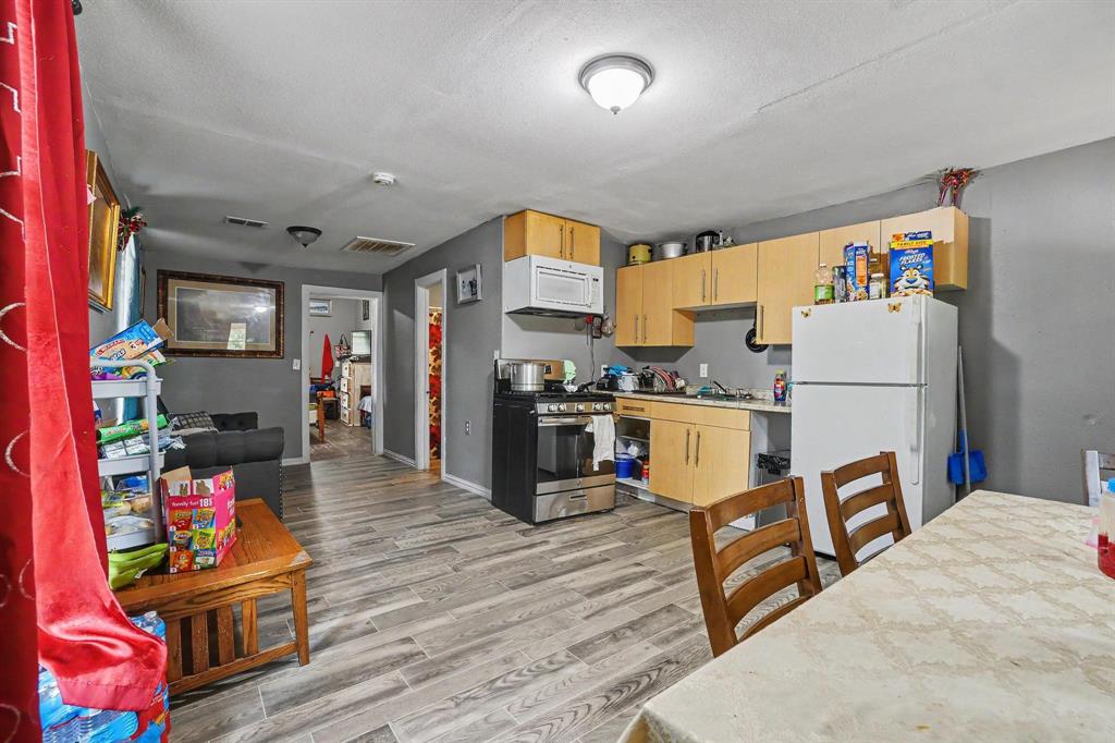 205 South Main Street Bonham, TX 75418 - Photo 11 of 23 a open kitchen with stainless steel appliances granite countertop a refrigerator and a stove top oven