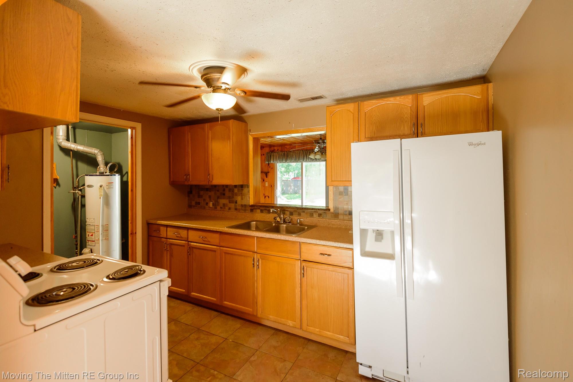 26247 Weigel Road New Boston, MI 48164 - Photo 11 of 30 Kitchen with wood-finish cabinetry, tile flooring, and a ceiling fan with integrated lighting