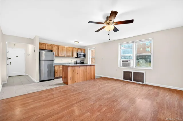 a view of empty room with wooden floor and window