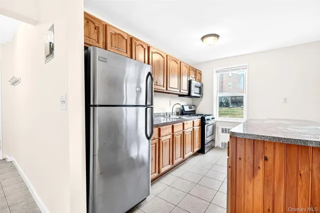 a kitchen with stainless steel appliances granite countertop a refrigerator and a sink