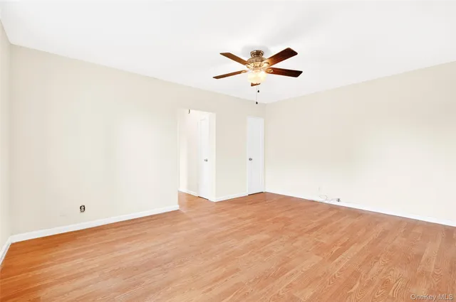 a view of a room with wooden floor and a ceiling fan