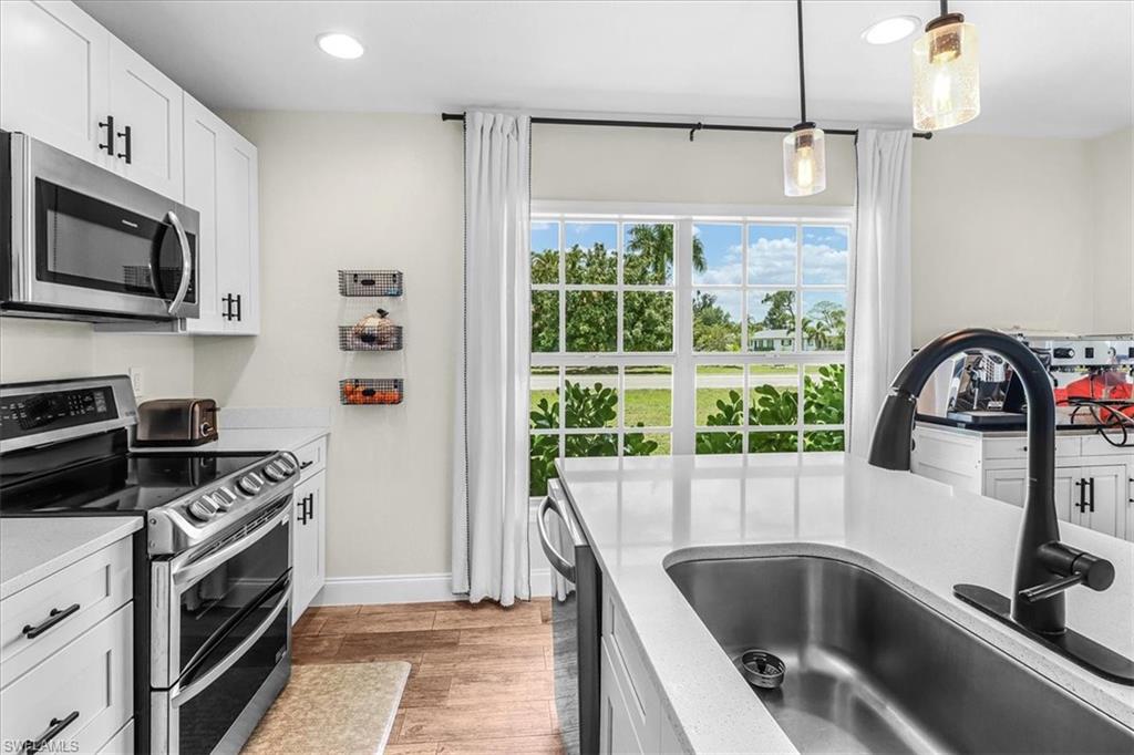 18601 Geranium Road Fort Myers, FL 33967 - Photo 7 of 34 a kitchen with a sink a stove and microwave