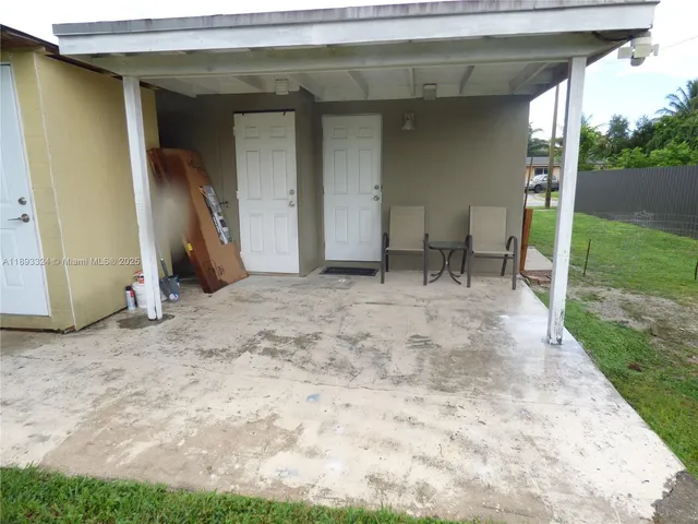 a view of a porch with a table and chairs