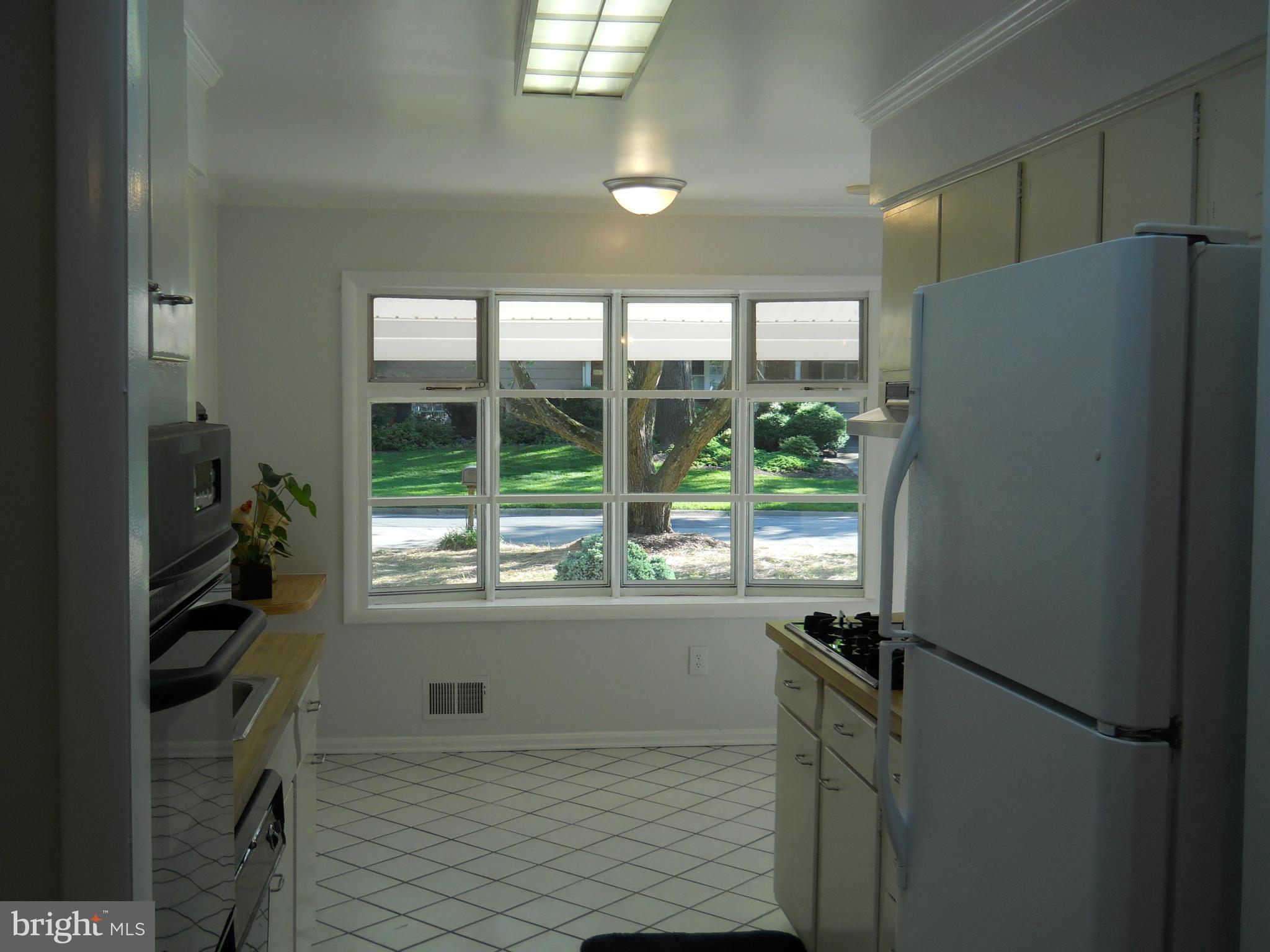13145 Clifton Road Silver Spring, MD 20904 - Photo 11 of 30 a kitchen with a refrigerator a stove and a large window