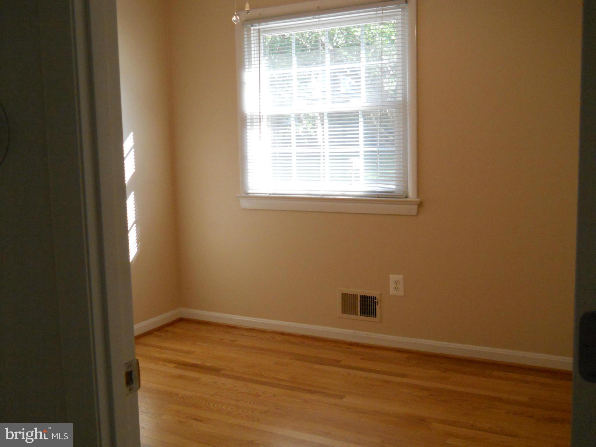 13145 Clifton Road Silver Spring, MD 20904 - Photo 19 of 30 a view of an empty room with wooden floor and a window