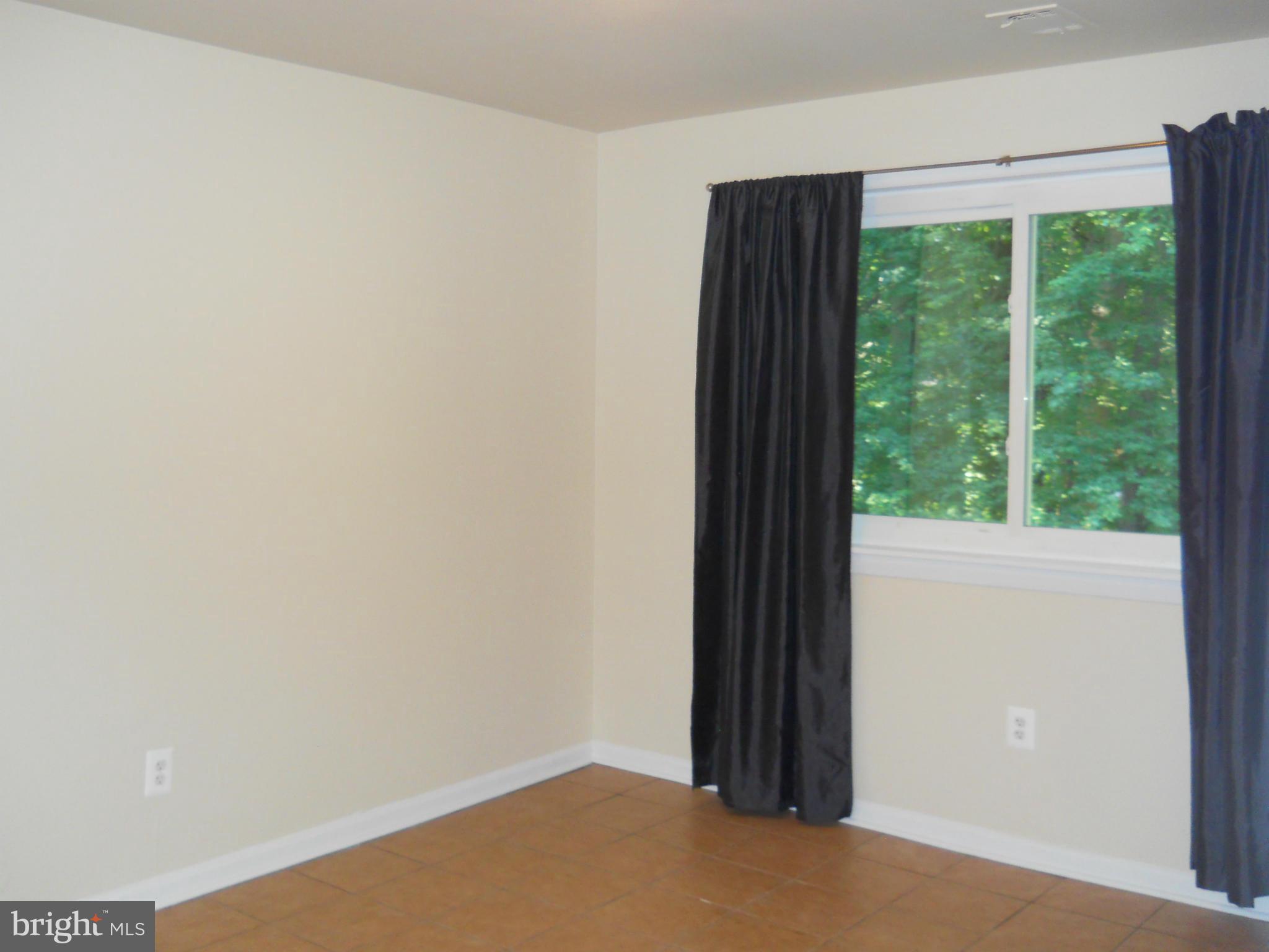 13145 Clifton Road Silver Spring, MD 20904 - Photo 22 of 30 an empty room with wooden floor and windows