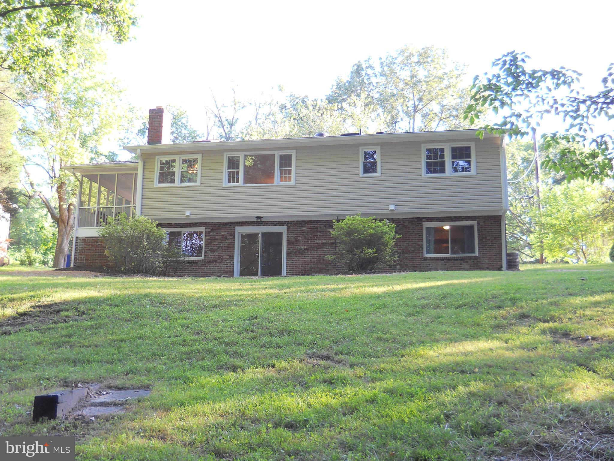 13145 Clifton Road Silver Spring, MD 20904 - Photo 27 of 30 a view of a yard in front of a house with large windows