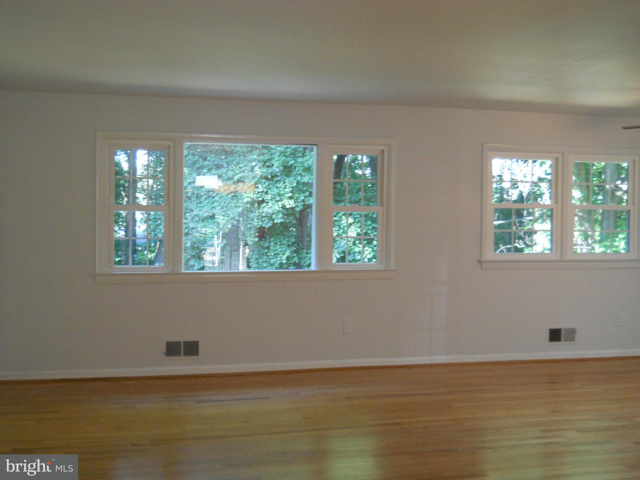 13145 Clifton Road Silver Spring, MD 20904 - Photo 6 of 30 a view of an empty room with wooden floor and a window