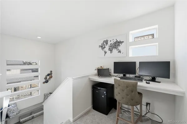 a view of a workspace with furniture and a window