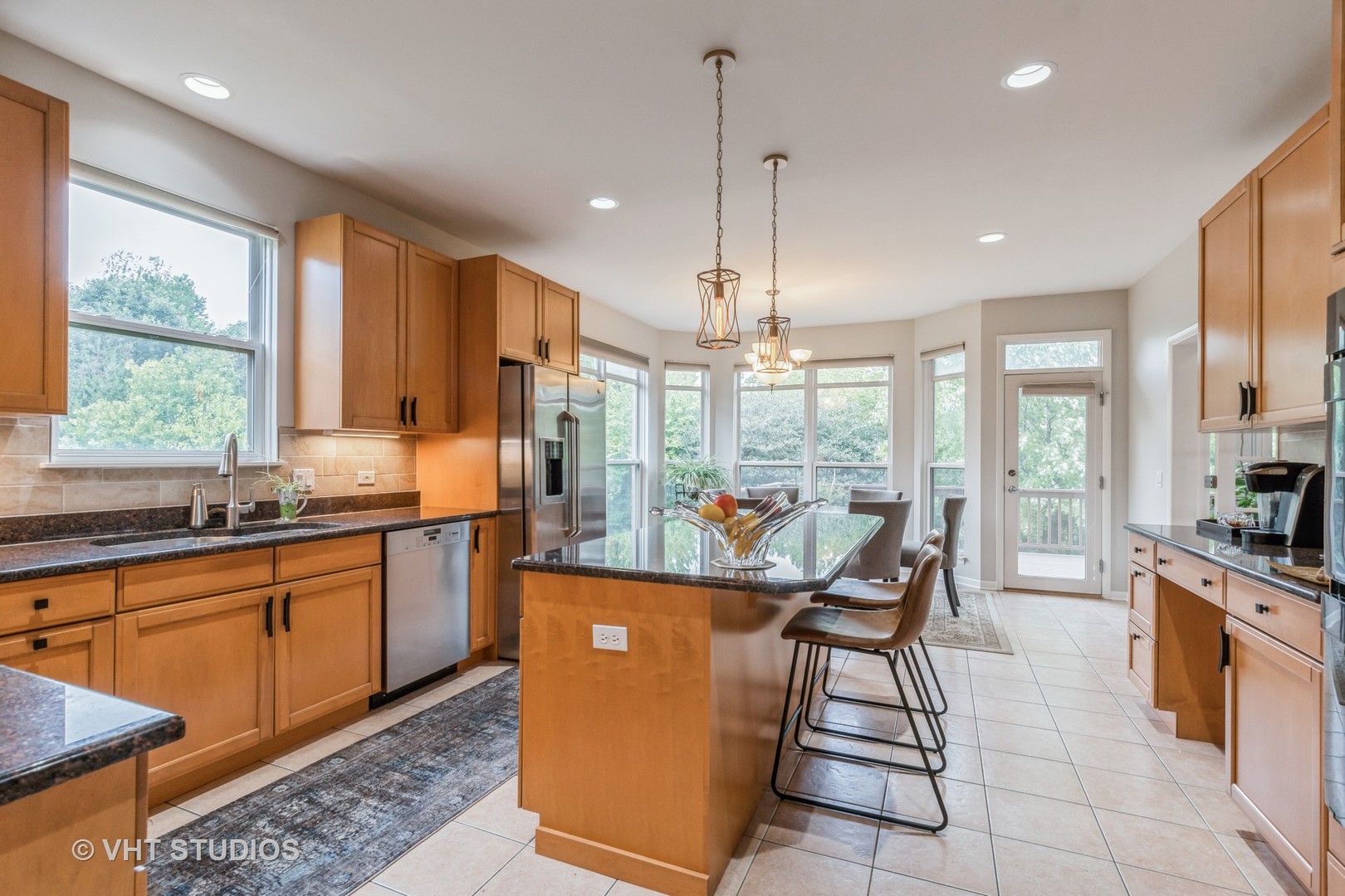 190 Janes Loop Highwood, IL 60040 - Photo 12 of 34 a kitchen with stainless steel appliances granite countertop a stove top oven a sink dishwasher a dining table and chairs with wooden floor