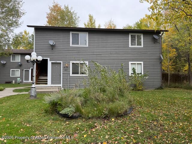 a brick house with a yard plants in front of it