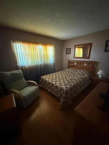 a bed sitting in a bedroom next to a window