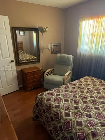 a bedroom with a bed and painting on the wall