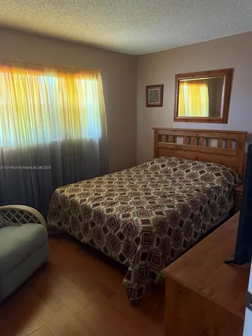 a bedroom with a bed and two windows