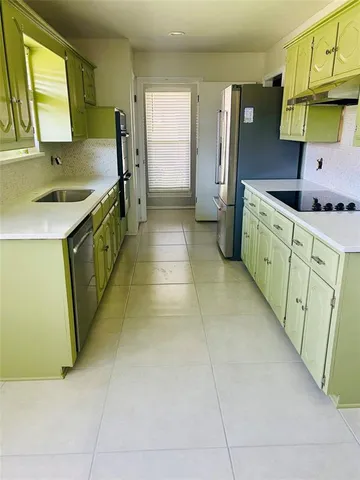 a kitchen with stainless steel appliances granite countertop a sink and a refrigerator