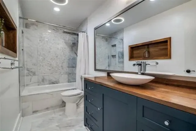 a bathroom with a granite countertop sink toilet and shower