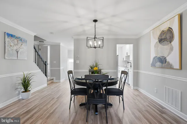 a dining room with furniture potted plants and wooden floor