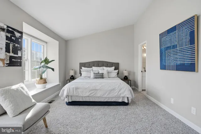 a bedroom with a bed couch and a window