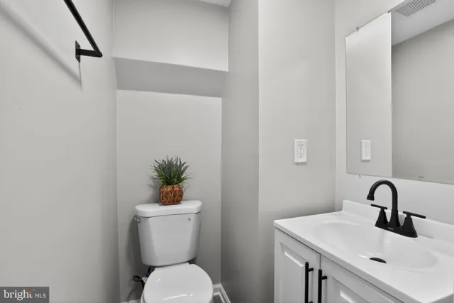 a bathroom with a sink a toilet and a mirror