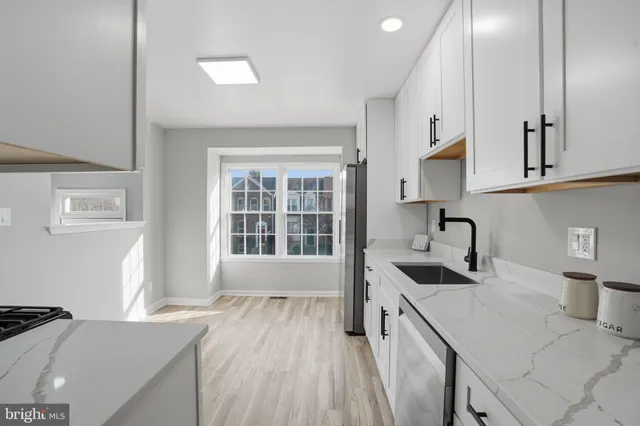 a kitchen with granite countertop a sink stove and cabinets