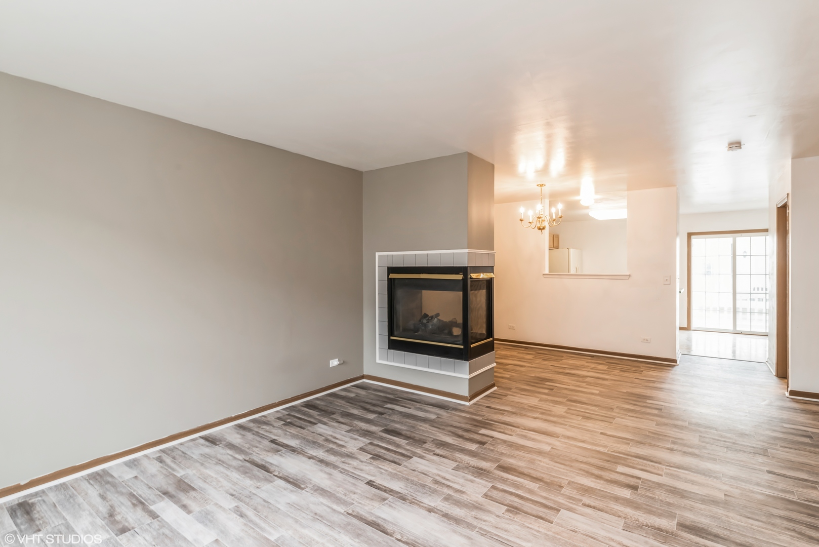 274 Holiday Lane Hainesville, IL 60073 - Photo 16 of 20 an empty room with wooden floor fireplace and windows