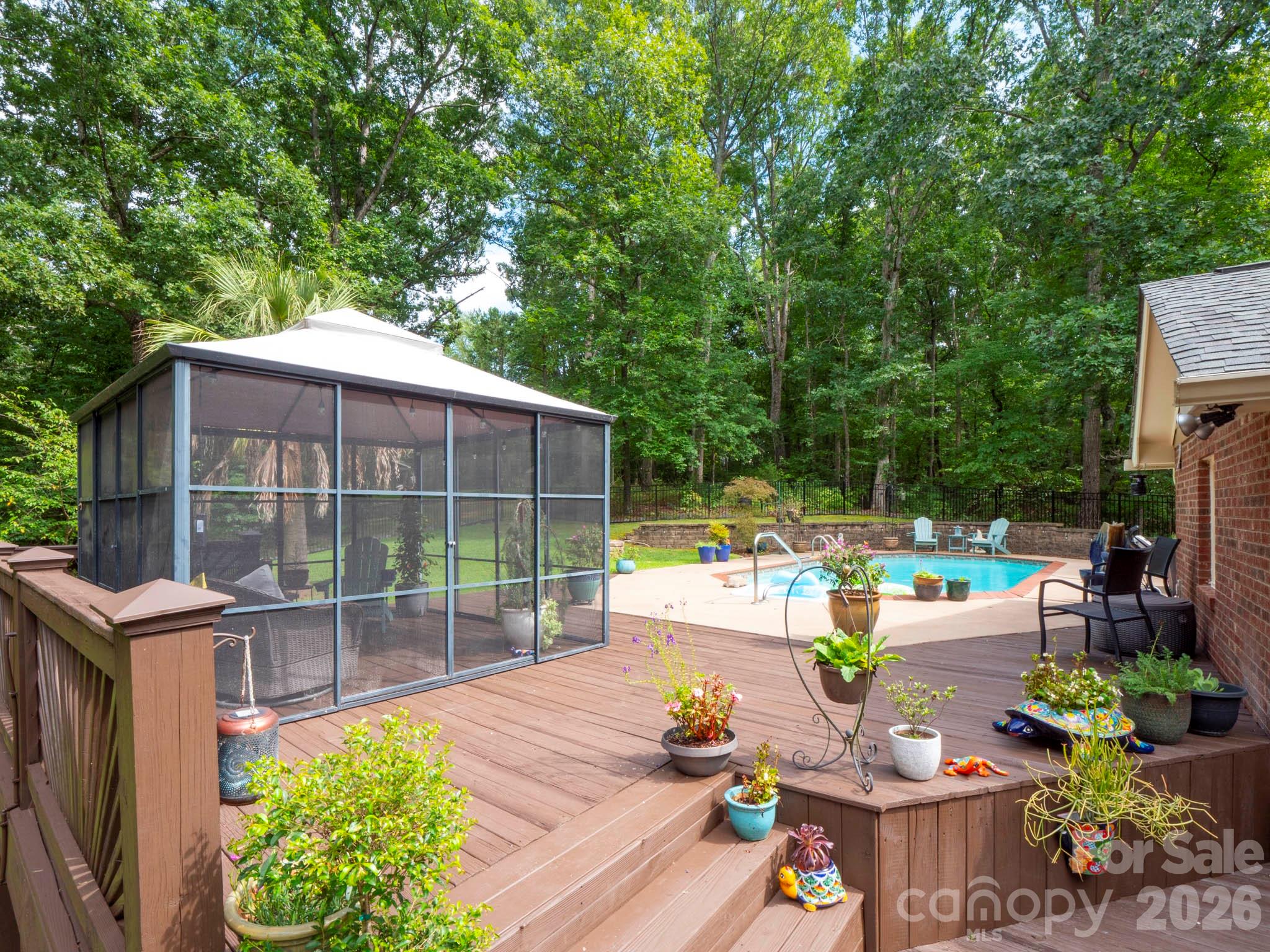 8720 Unionville-Brief Road Monroe, NC 28110 - Photo 15 of 35 a view of a patio with table and chairs potted plants with wooden floor and fence