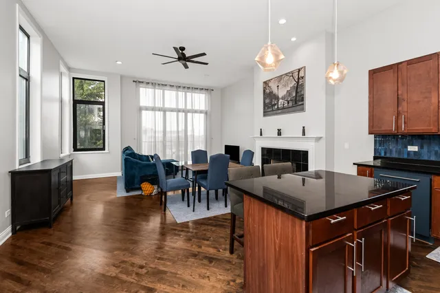 a very nice looking kitchen with granite countertop a stove a sink a dining table and chairs