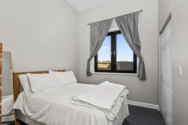 a bedroom with a bed and a large window