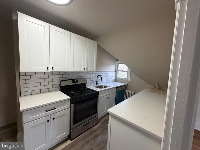 a kitchen with cabinets appliances and a window