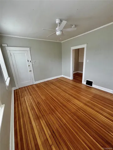 a view of empty room with wooden floor