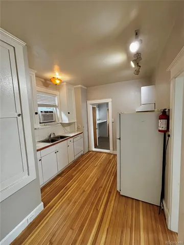 a large kitchen with a sink and refrigerator