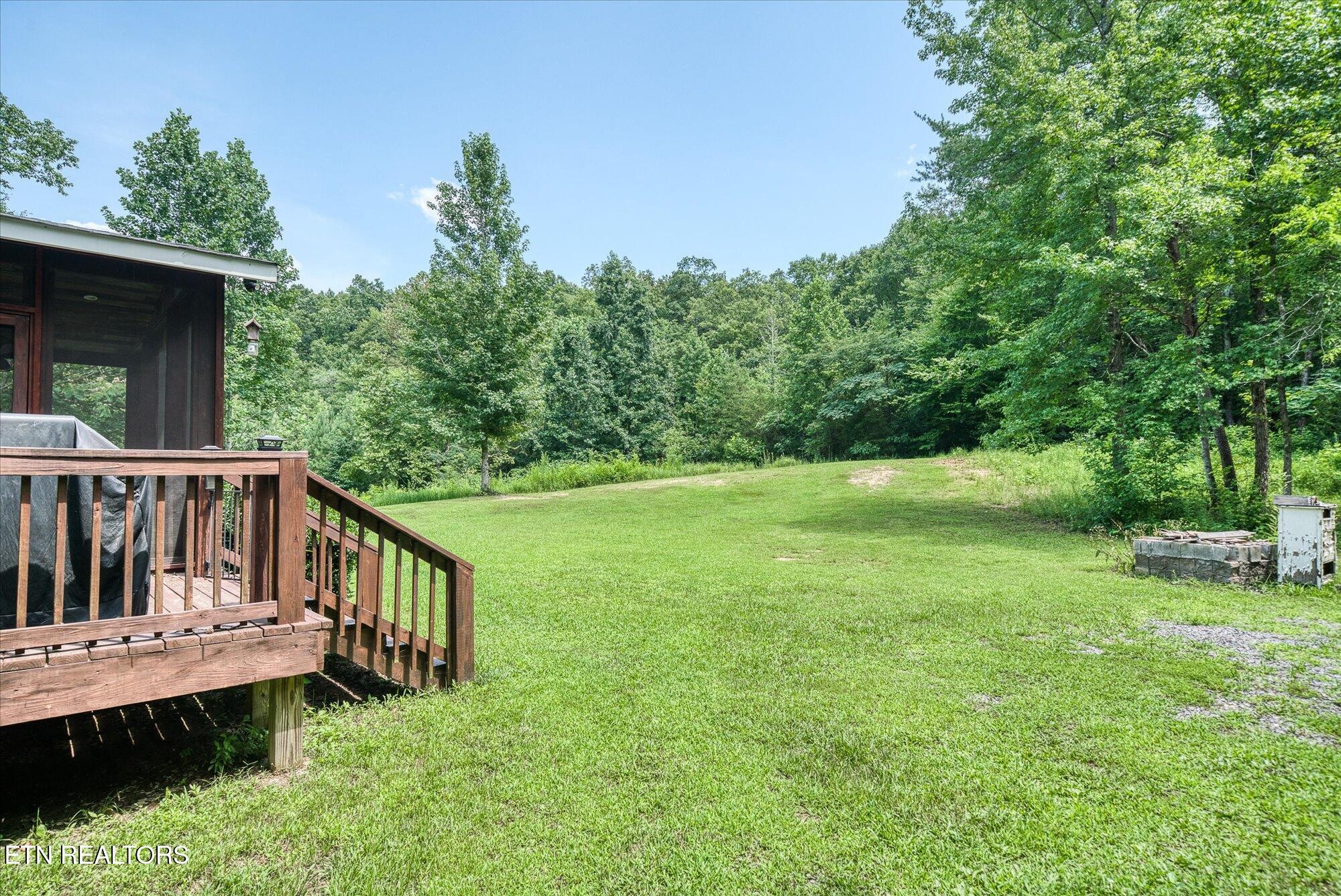 2029 Shiloh Road Decatur, TN 37322 - Photo 15 of 19 a view of a deck with a table and chair under an umbrella