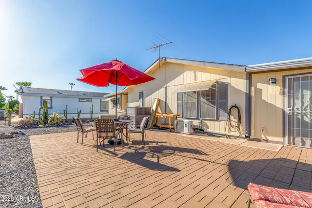 a view of a patio with a table and chairs under an umbrella