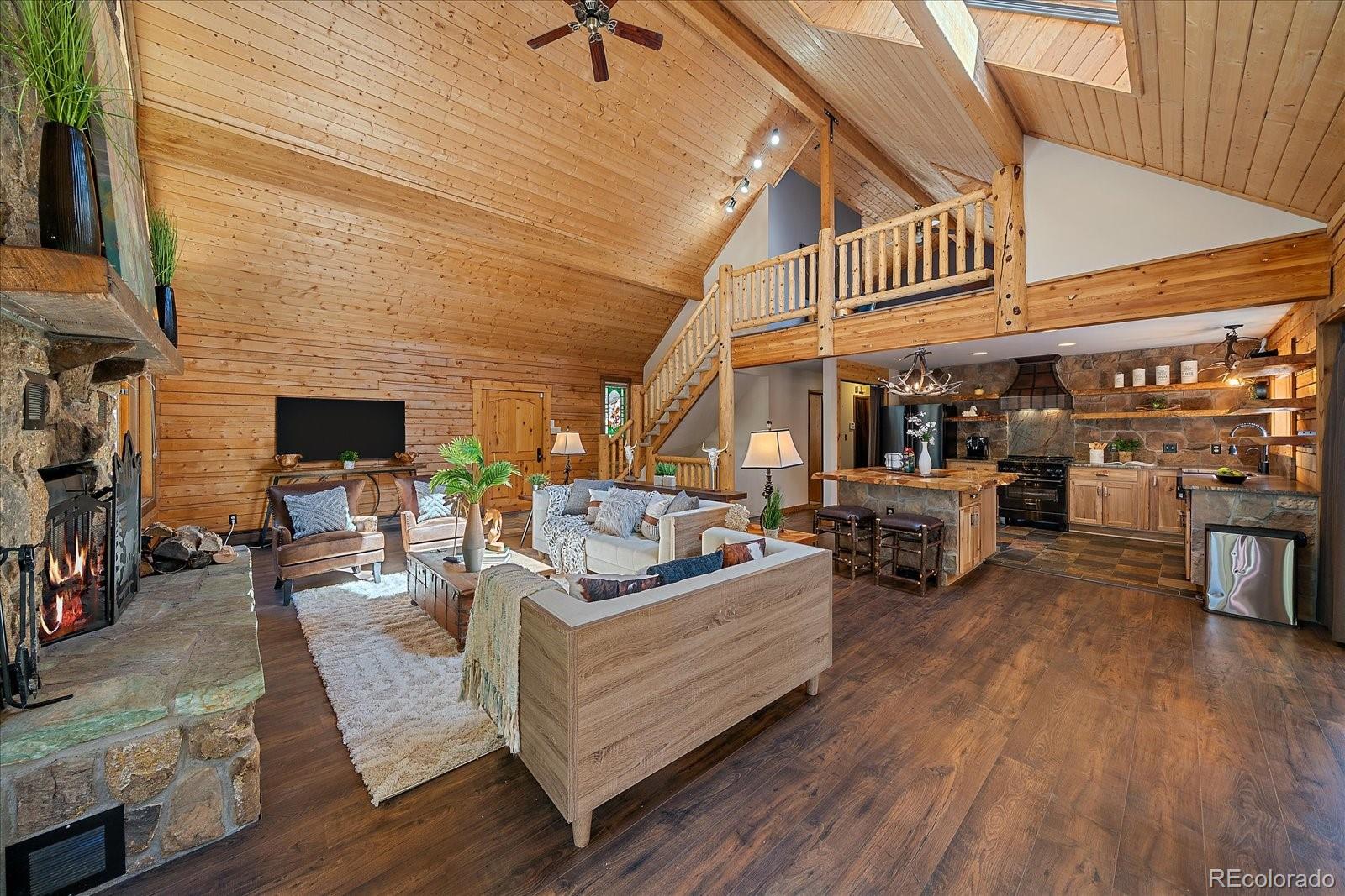 1385 Beaver Brook Canyon Road Evergreen, CO 80439 - Photo 10 of 49 a living room with furniture and a fireplace
