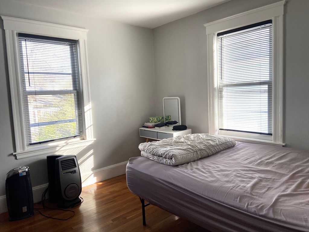 26 Harrison Street, Unit 1 Quincy, MA 02169 - Photo 11 of 14 a bedroom with a bed and wooden floor