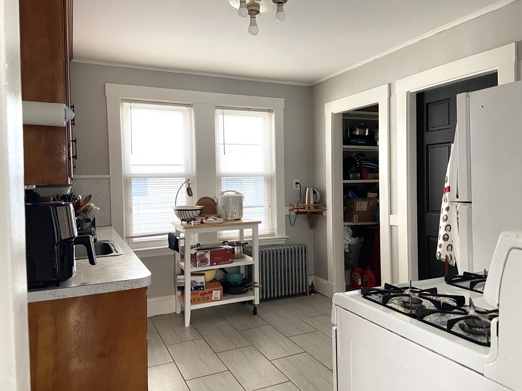 26 Harrison Street, Unit 1 Quincy, MA 02169 - Photo 5 of 14 a view of a kitchen with fridge and workspace