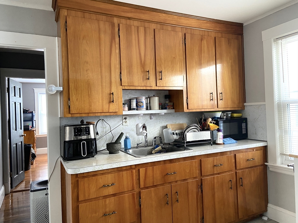 26 Harrison Street, Unit 1 Quincy, MA 02169 - Photo 6 of 14 a kitchen with stainless steel appliances granite countertop a refrigerator a sink a stove a microwave oven and cabinets