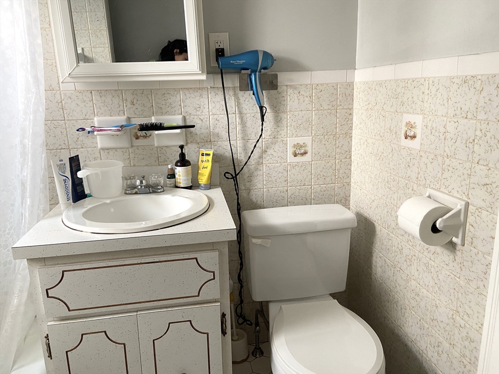 26 Harrison Street, Unit 1 Quincy, MA 02169 - Photo 8 of 14 a bathroom with a sink a toilet and a mirror